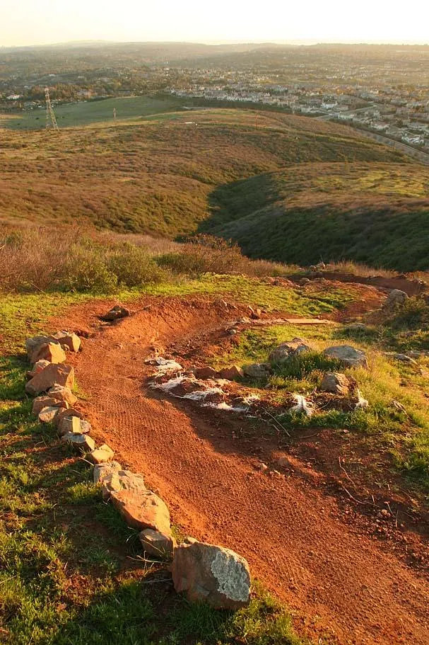 Singletrack trail winding over golden hills above North County San Diego